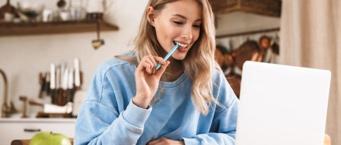 Woman in Sweatshirt on Laptop at Home