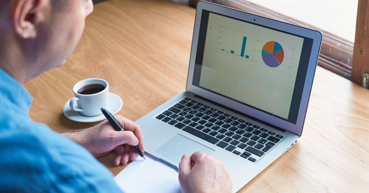 Man Looking at Charts on Laptop