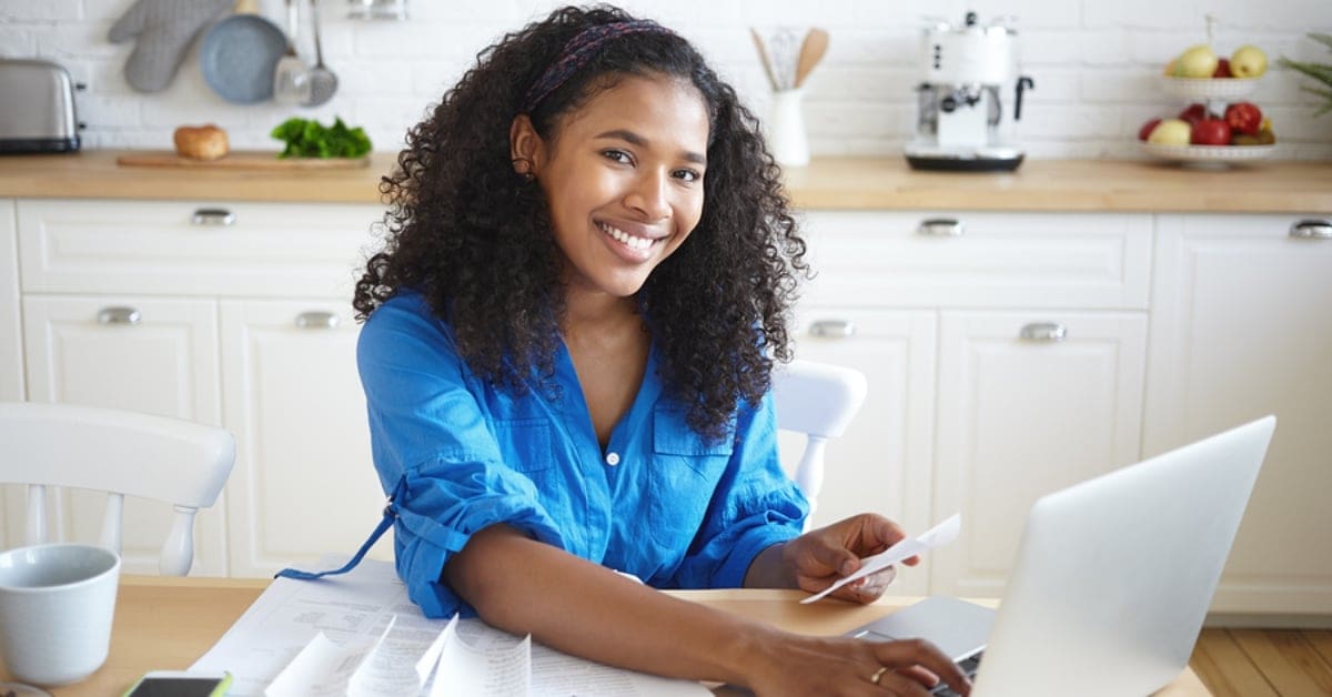 African American Woman in Kitchen on Laptop