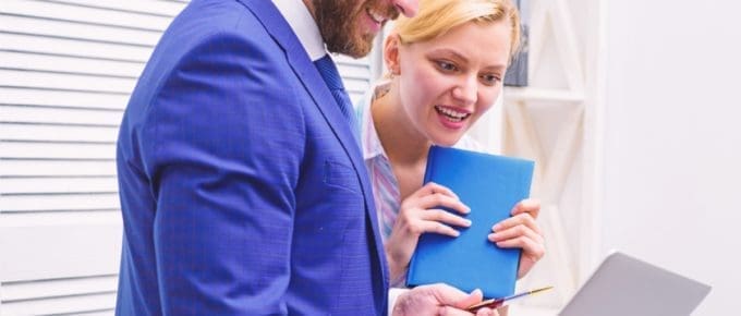 Man and Woman Looking at Laptop