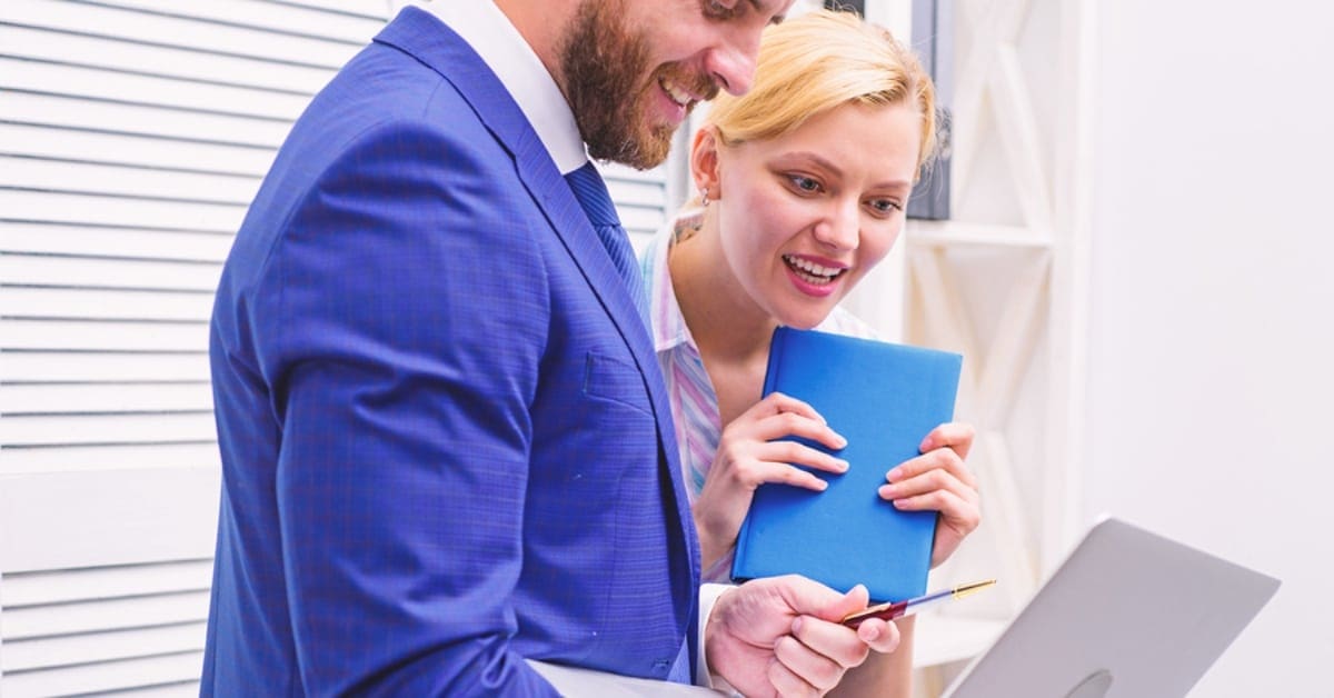 Man and Woman Looking at Laptop