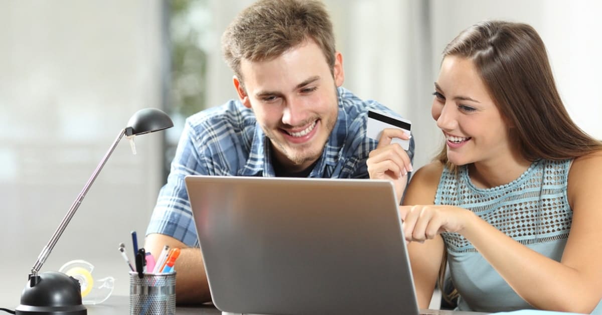 Guy and Girl on Laptop Smiling Pointing