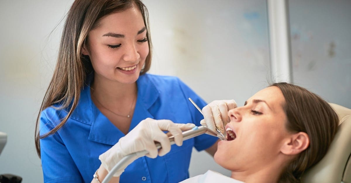 Dentist Cleaning Patient's Teeth