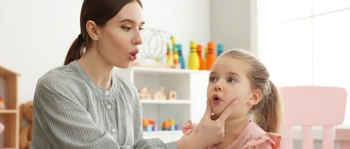 Woman Pursing Little Girls Lips for Speech