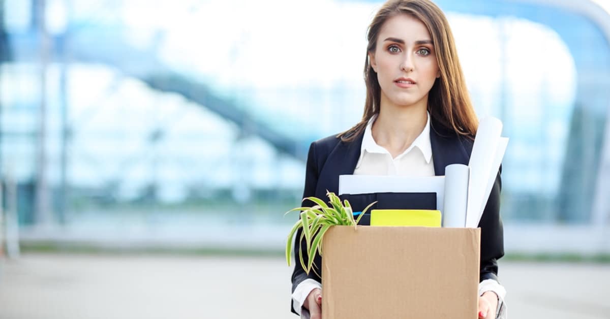 Woman Walking Out with Box of Her Office Belongings