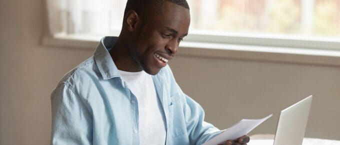 African American Man in Smiling at Paperwork