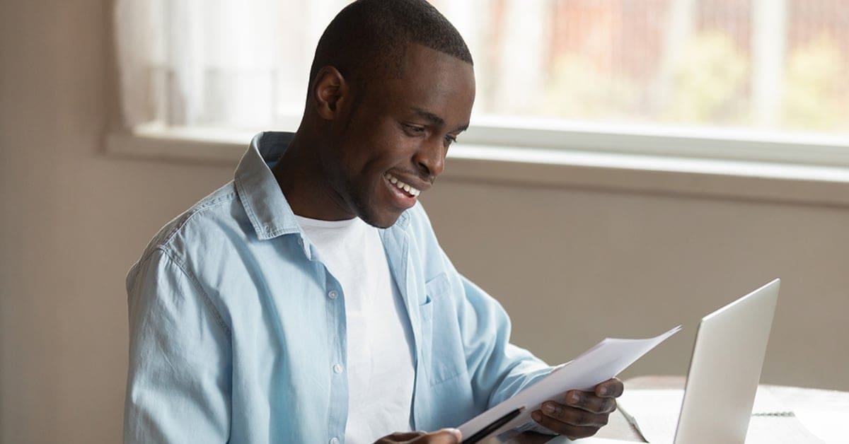 African American Man in Smiling at Paperwork