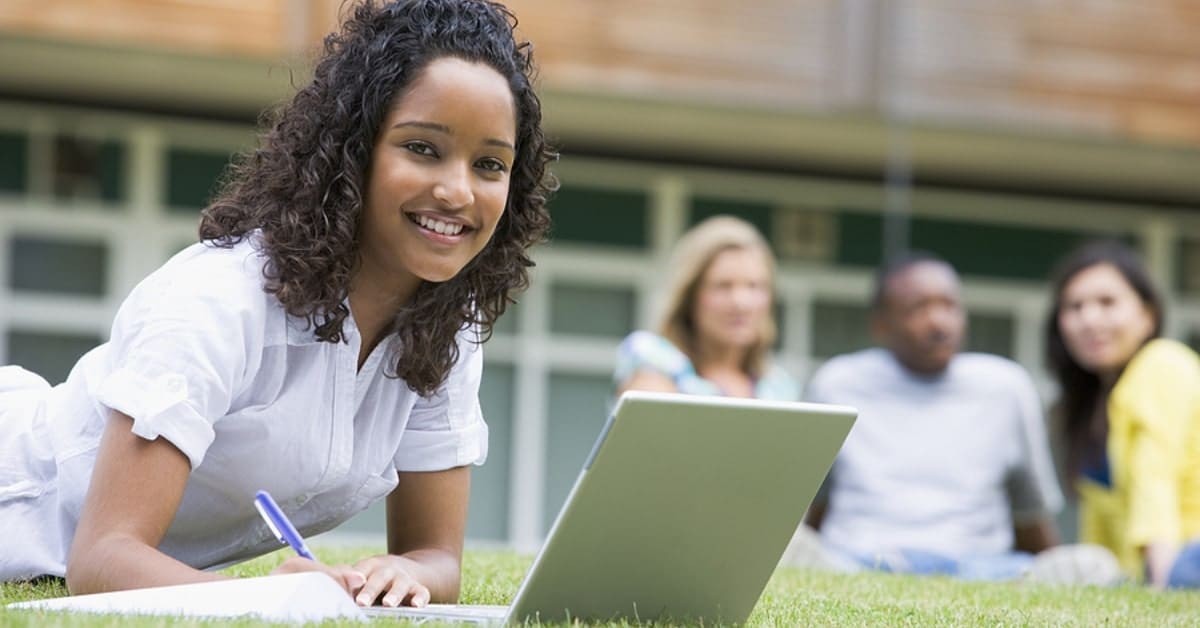 Female Teen Smiling for Camera Doing Schoolwork