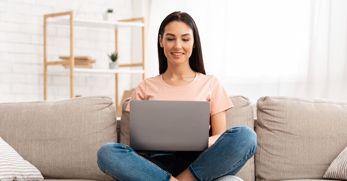 Woman Criss Cross on Couch on Computer
