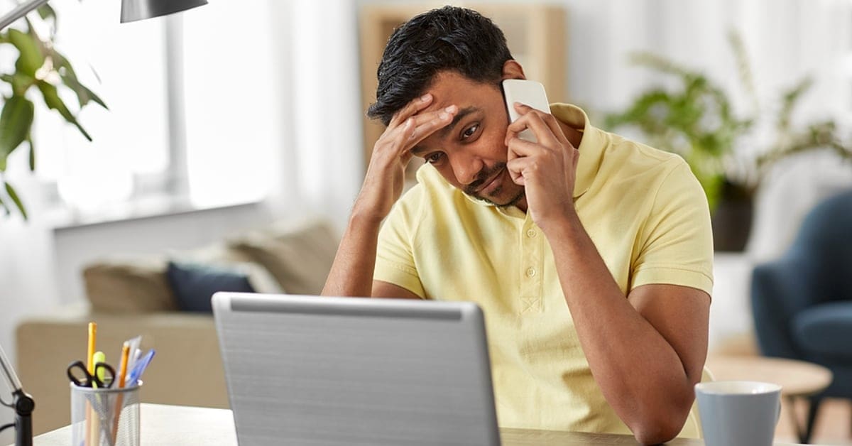 Man on Phone While Staring at Computer Screen