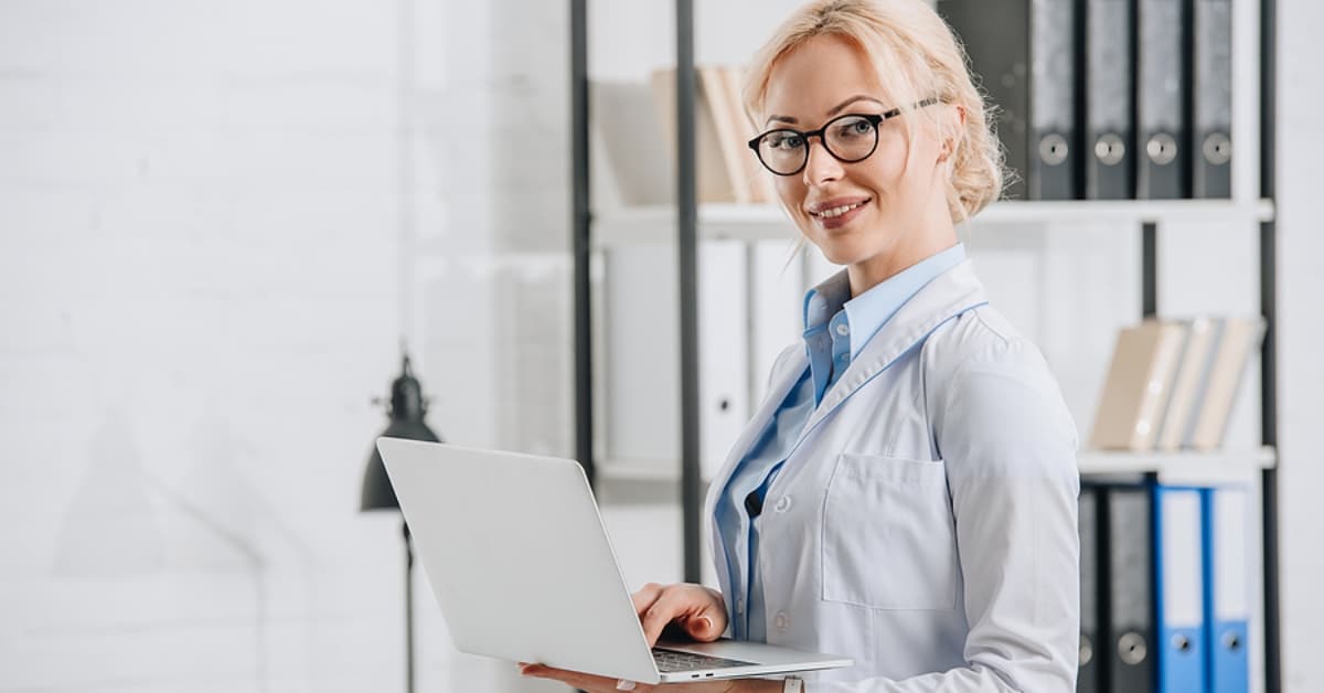 Woman on Laptop Smiling up at Camera