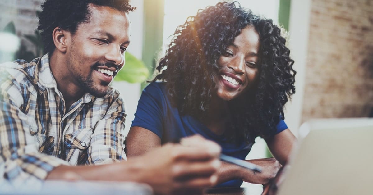 African American Couple Smiling Over Laptop