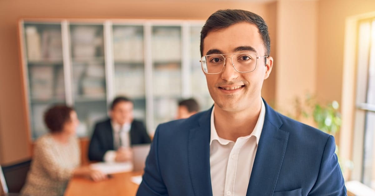 Professional Man Smiling for Camera at Conference Table