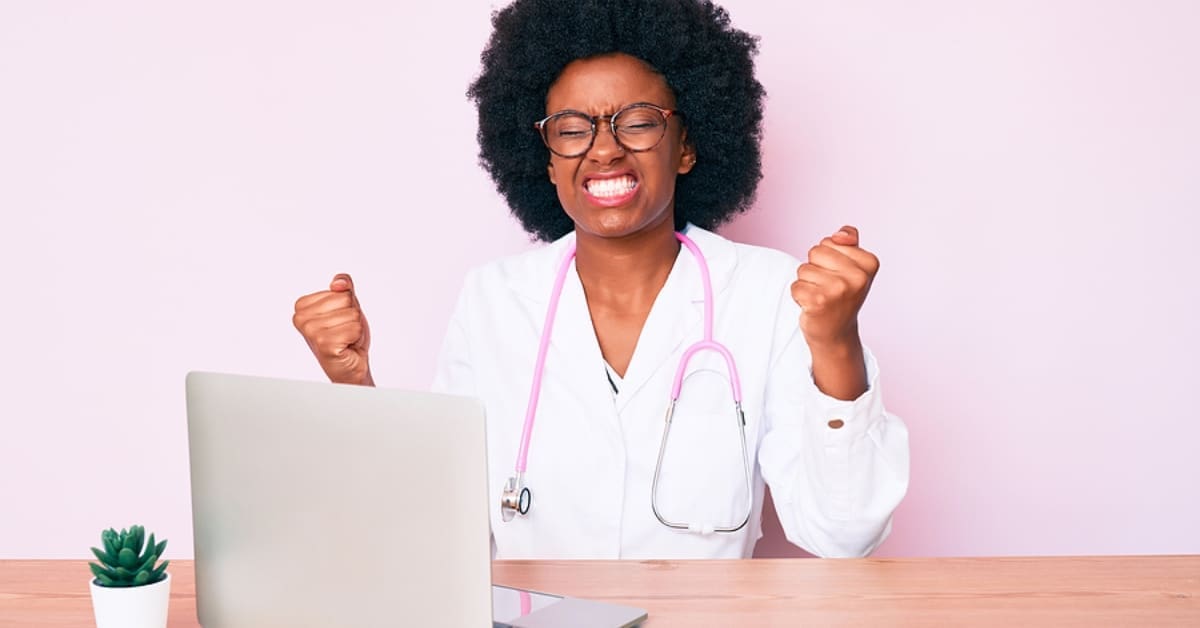 African American Woman Celebrating in Front of Laptop