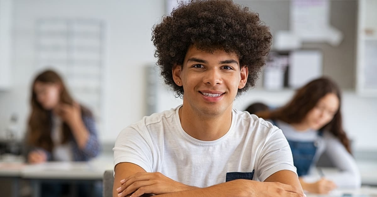 African American Young Man Smiling for Camera in Classroom