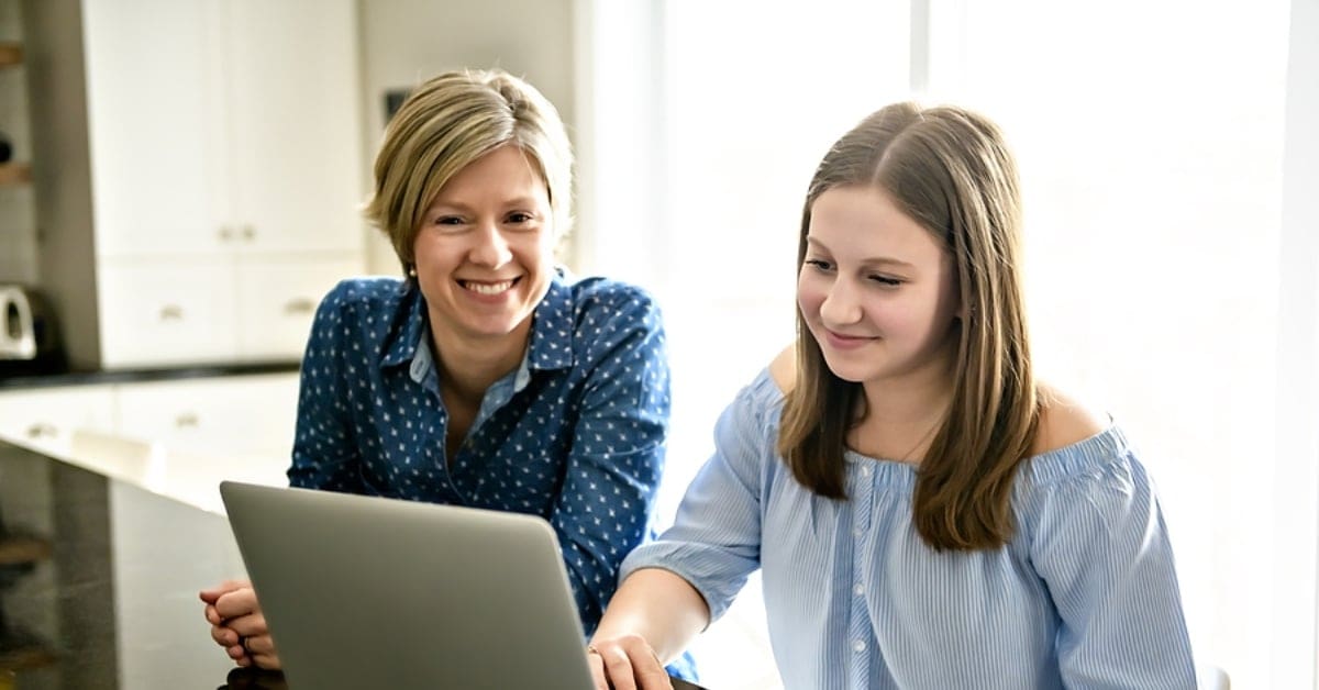 Mother and Daughter Smiling Looking at Laptop