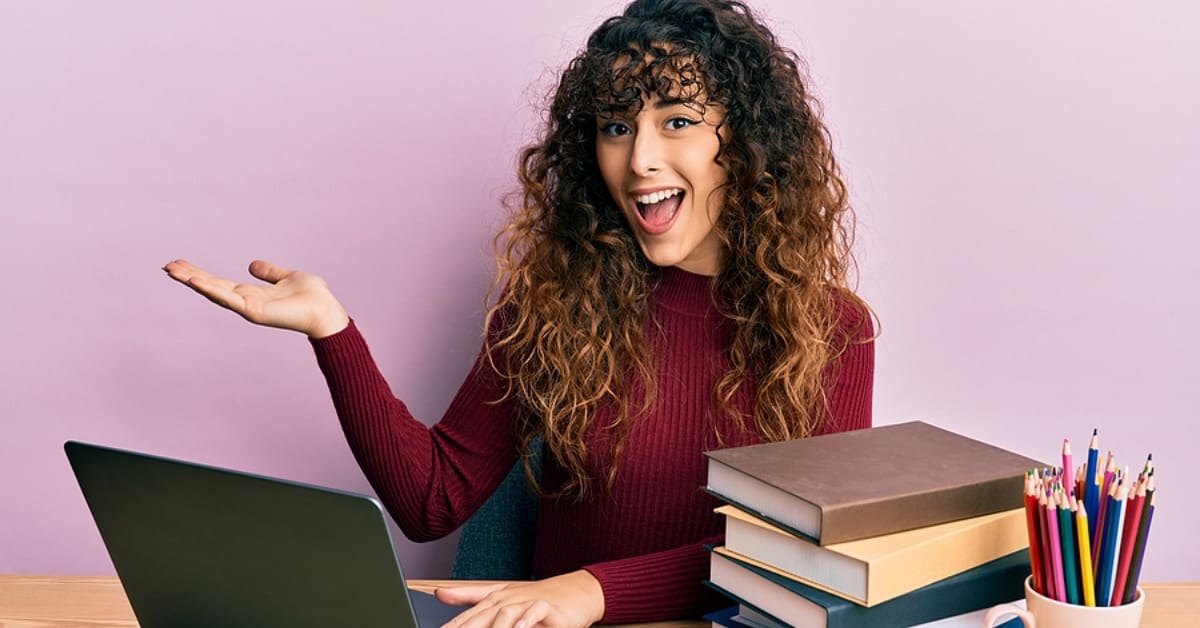 Woman with Palm Up Smiling While on Laptop