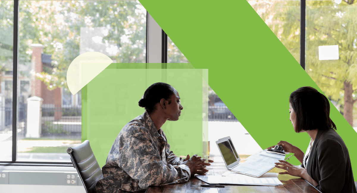 A woman in an army suit talking with another woman at a table