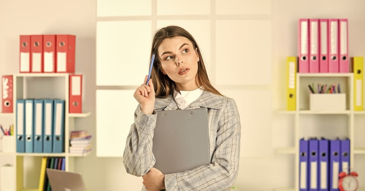 Woman Holding Pen to Head Thinking