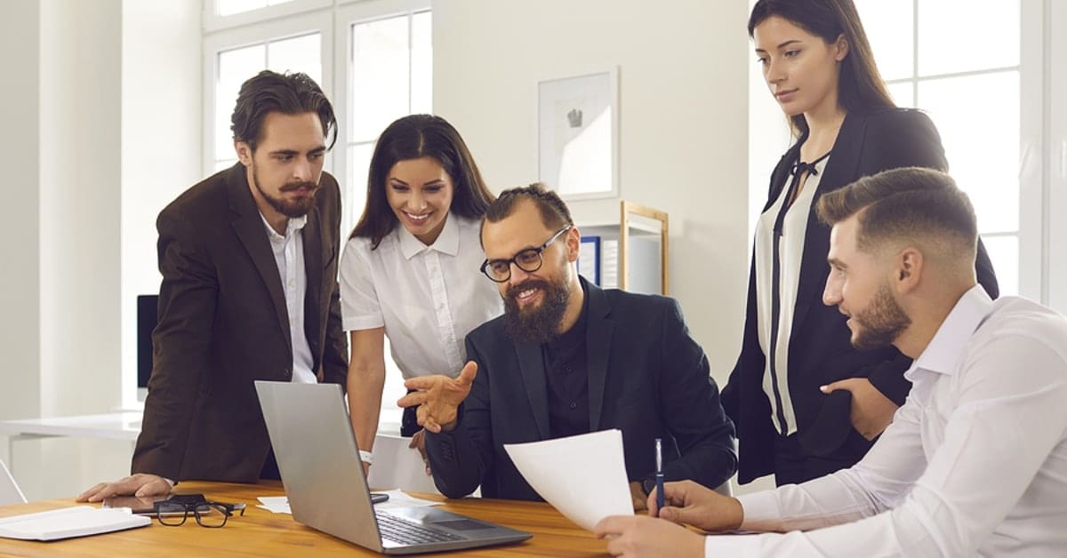 Group of People at Work Looking at One Laptop