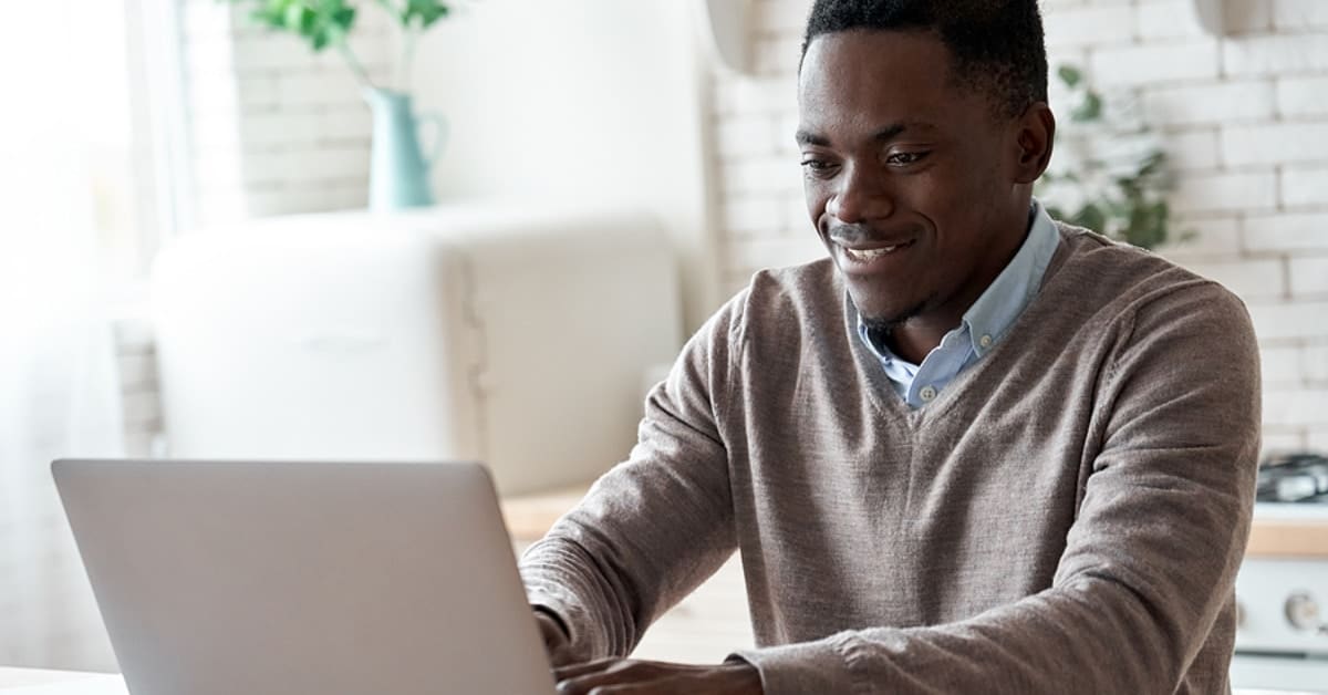 African American Man Smiling Looking at Computer