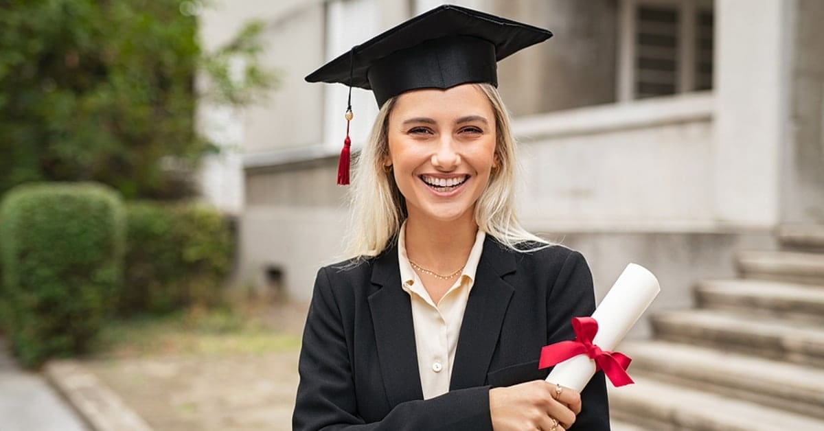 Blonde Woman Smiling in Graduation Garb with Diploma