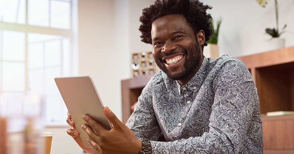 African American Man Smiling Holding Tablet