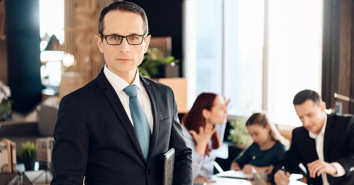 professional male looking at camera with family in background