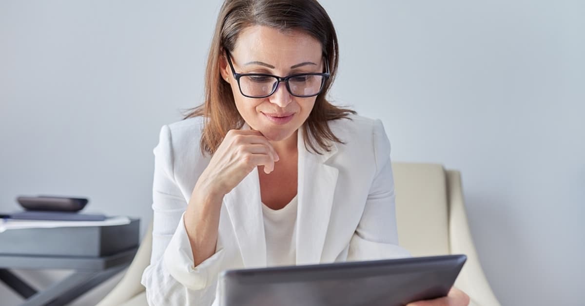female in glasses looking at laptop