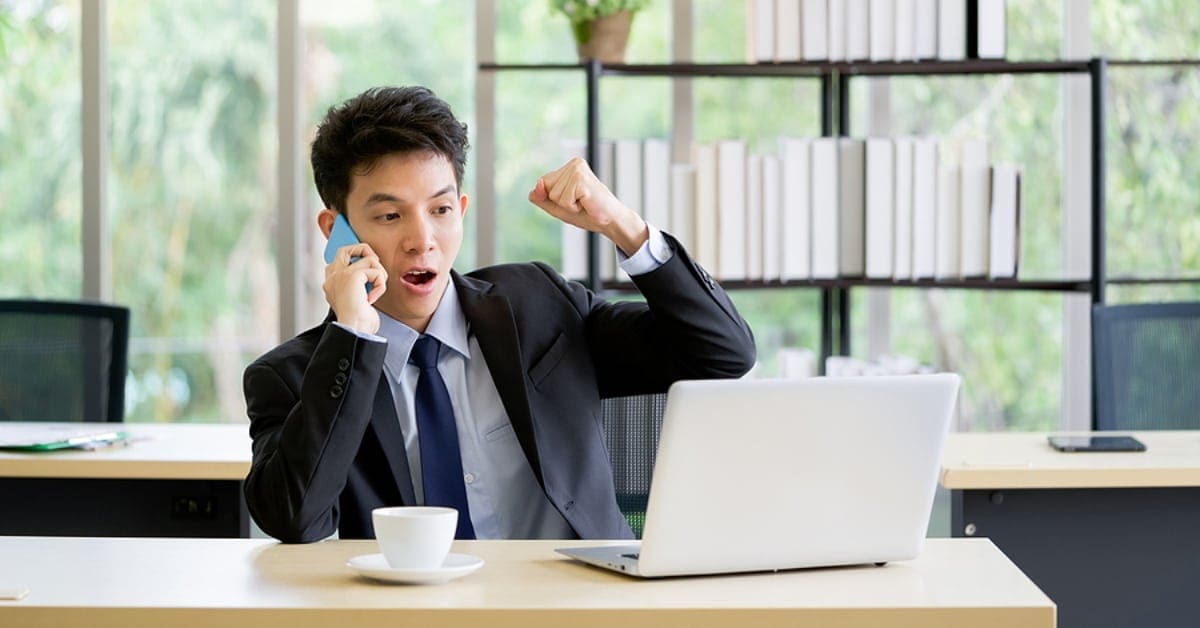 young asian professional cheering on phone