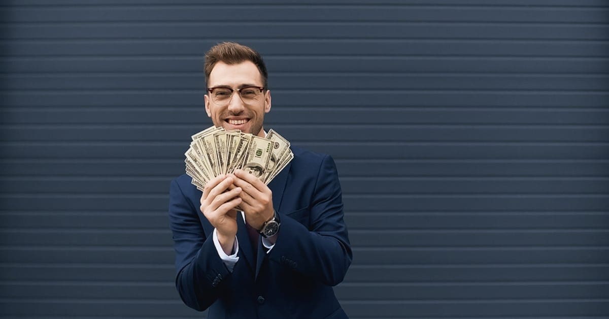 Man Smiling Holding Lots of Cash