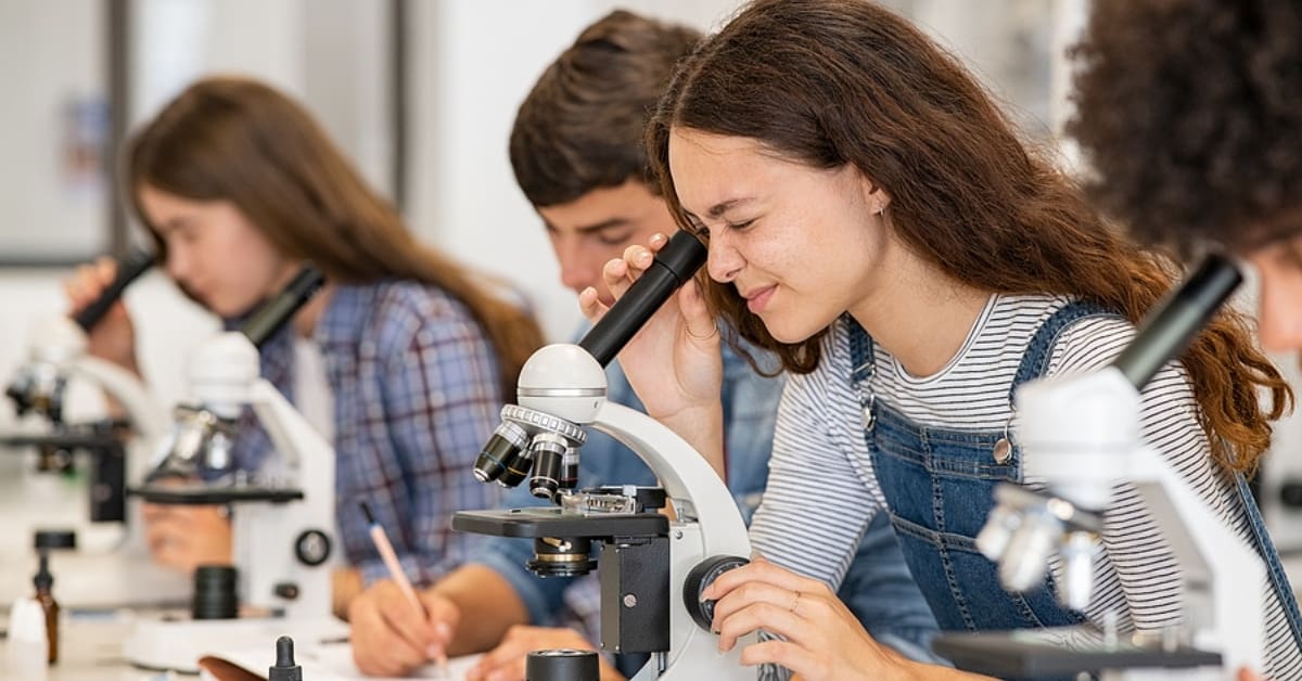 Teenagers in Classroom Looking into Microscopes