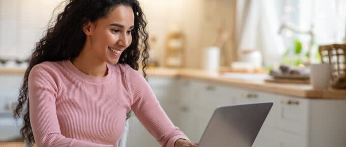 Woman Smiling Looking at her Laptop