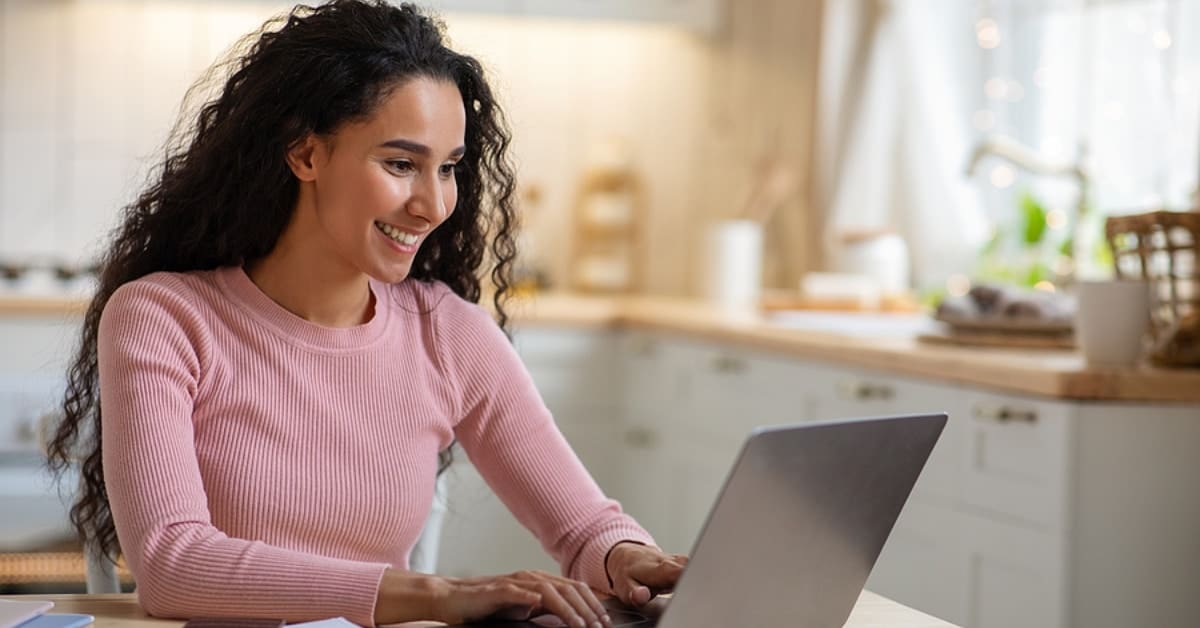 Woman Smiling Looking at her Laptop