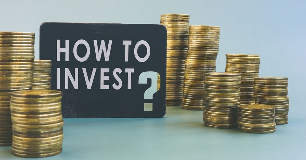 Sign saying "How to Invest" with Stacks of Coins Surrounding it