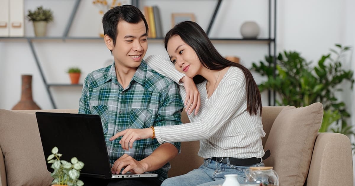 Asian Couple Looking at Laptop Together