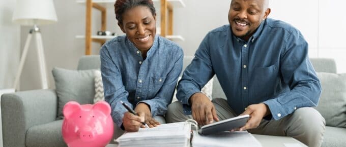 African American Couple Smiling While Reviewing Financial Information Together