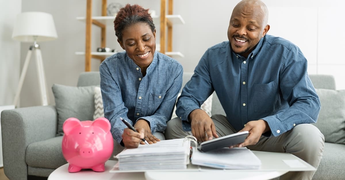 African American Couple Smiling While Reviewing Financial Information Together