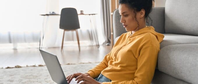 Woman Sitting on the Ground on her Laptop