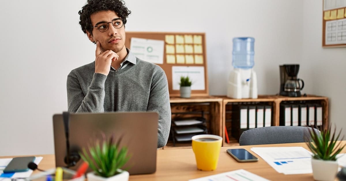 Man Pondering While Sitting at Laptop