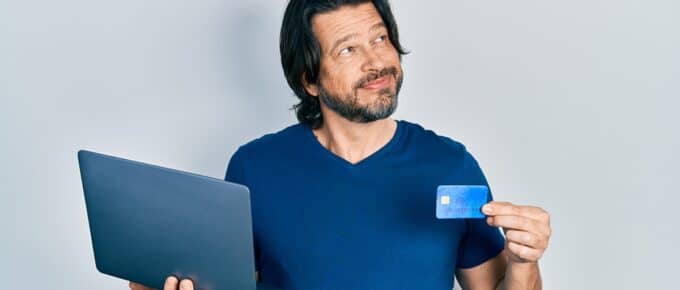 Man Holding Credit Card and Laptop