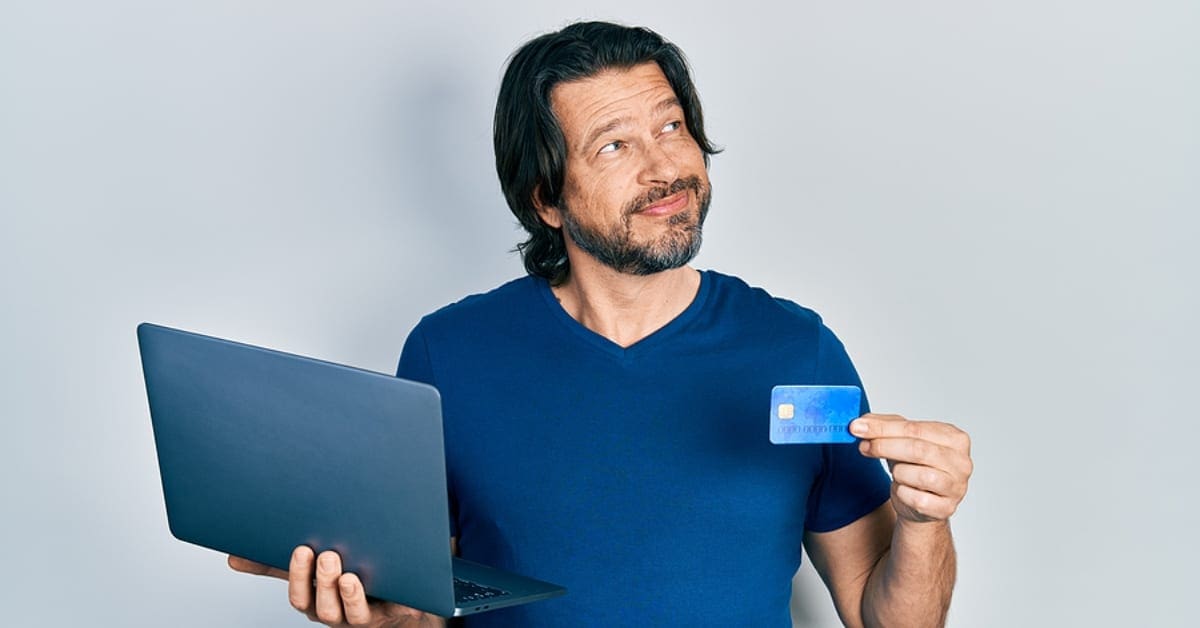 Man Holding Credit Card and Laptop
