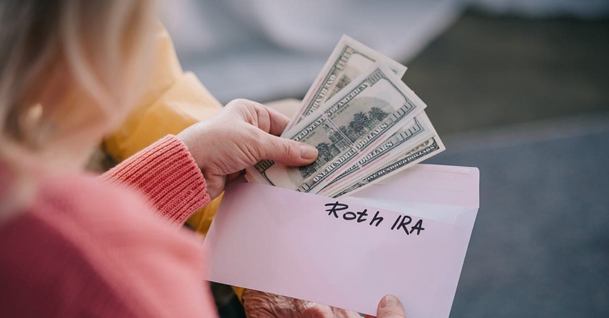 Roth IRA Labeled Envelope with Money Being Taken out of it