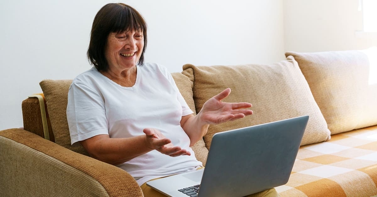 Elderly Caucasian Woman Celebrating in Front of Laptop