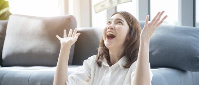 Asian Woman Throwing Money in the Air Celebrating