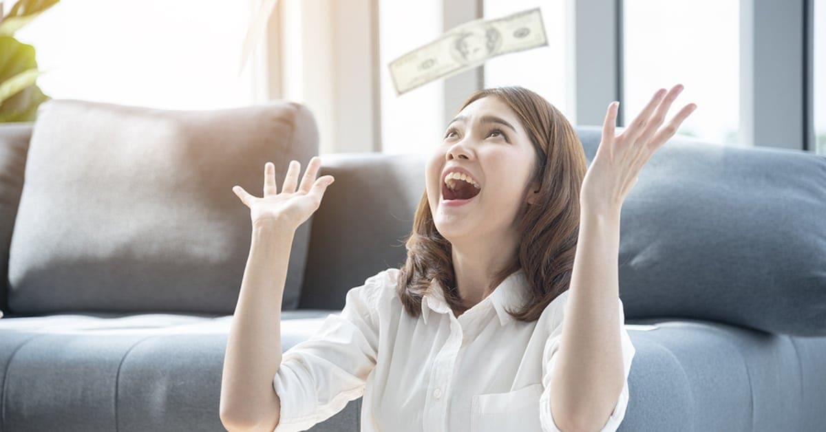 Asian Woman Throwing Money in the Air Celebrating