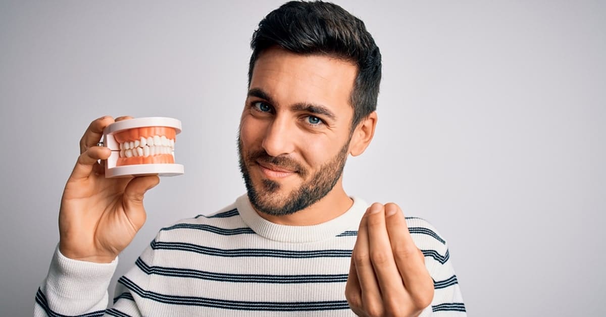 Man Posing Holding a Teeth/Jaw Model