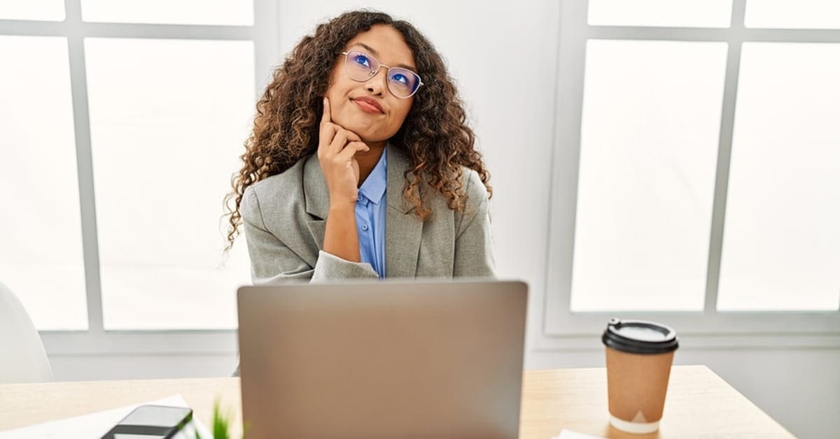 Female in Pondering Pose in Front of Laptop