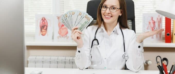 Caucasian Physician Holding Hundreds of Dollars in her Hand Smiling for Camera