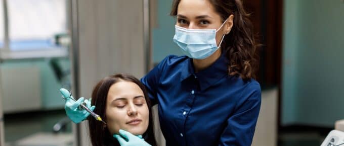 Female Posing with Patient Delivering Injections to Patient's Face